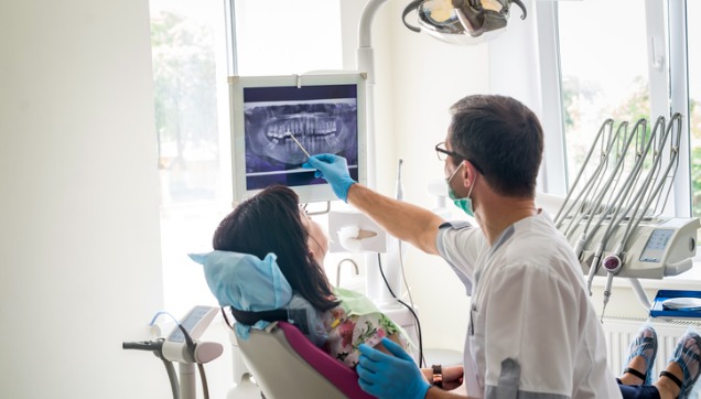 Dentist showing a tooth x-ray to a patient