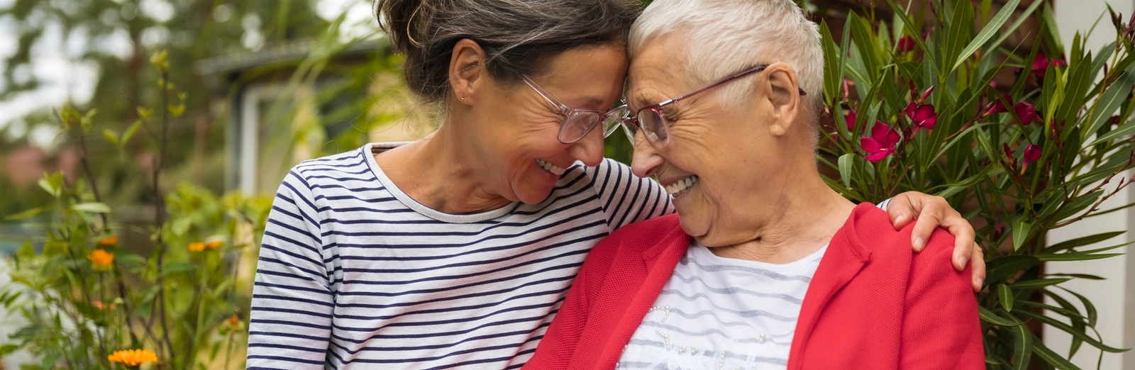 two-older-women-smiling-at-each-other-1600x522.webp