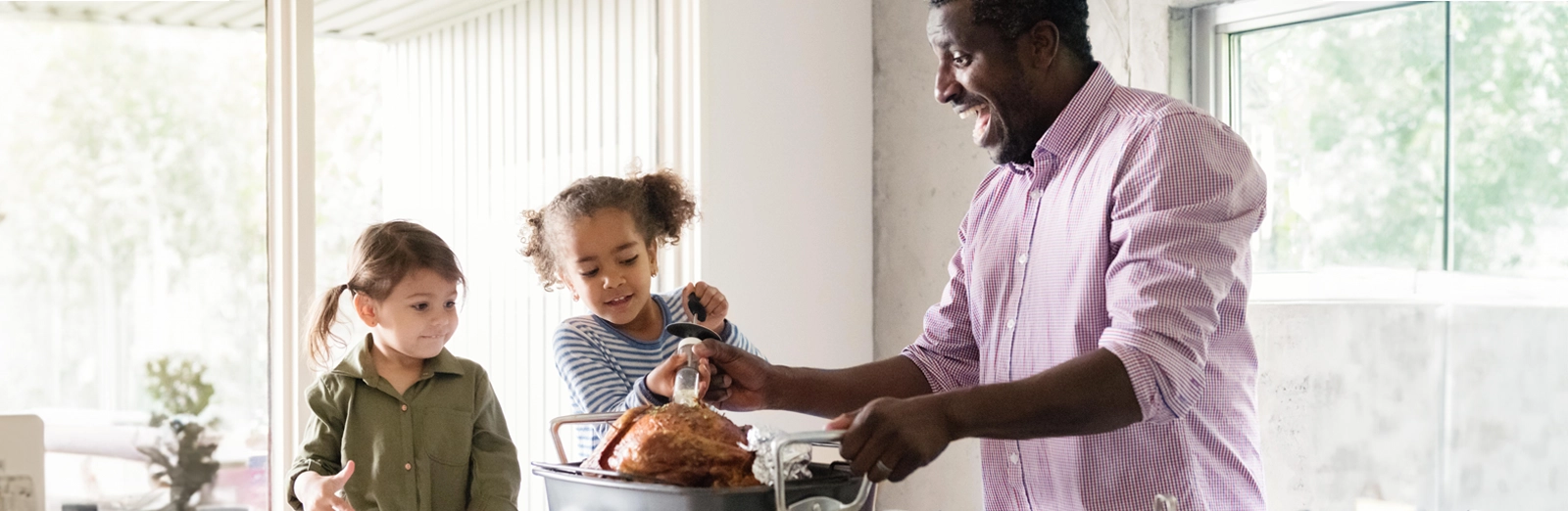 dad-and-daughters-cooking-a-turkey-1600x522.webp