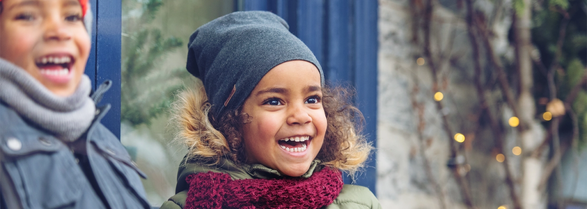 children-smiling-outside-in-the-winter-2000x714.webp